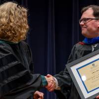 Provost Drake shaking Chris Haven's hand